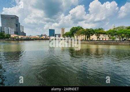 Singapore. Gennaio 2020. Il contrasto tra le case dei negozi lungo il fiume Singapore e i moderni grattacieli sullo sfondo Foto Stock