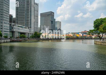 Singapore. Gennaio 2020. Il contrasto tra le case dei negozi lungo il fiume Singapore e i moderni grattacieli sullo sfondo Foto Stock