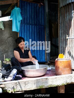 Le zone rurali del Vietnam non dispongono di lavatrici. Le donne in queste famiglie trascorrono ore al giorno lavando i loro vestiti. Foto Stock