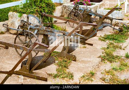 Antiche aratri in ferro in una fattoria nella campagna pugliese Foto Stock