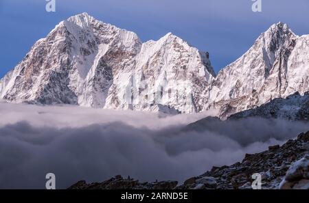 Maestose vette dell'Himalaya che torreggiano sopra le nuvole all'alba in Nepal, montagne dell'Himalaya Foto Stock
