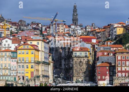 Fila di edifici sul lungofiume del Douro nella città di Porto, Portogallo. Vista con il campanile della chiesa di Clerigos Foto Stock