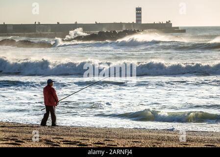 L'uomo la pesca dalla spiaggia in Foz do Douro distretto della città di Porto, la seconda più grande città in Portogallo Foto Stock