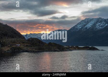 Drammatico tramonto nuvoloso su Øksfjorden, comune di Loppa, Vest-Finnmark, Norvegia settentrionale Foto Stock