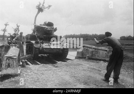 Azione con carri armati vicino a Toba e dintorni UN M3 Stuart Tank guida su un ponte provisoricamente costruito e ottiene indizi Annotazione: [2nd Squadron Fighters] Data: Marzo 1949 luogo: Indonesia, Java, Dutch East Indies, solo Foto Stock