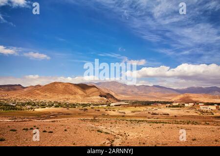 Nel sud del Marocco, vicino al villaggio di El Kelaa M'Gouna, una pista sterrata si snoda fino alle montagne innevate dell'atlante Foto Stock