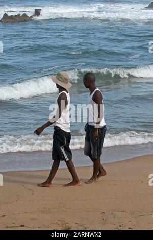 Due uomini a piedi sulla spiaggia, Umdloti, Costa Nord di KwaZulu-Natal, Sud Africa. Foto Stock