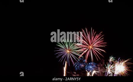 Fuochi d'artificio di stelle verdi, rosse, blu e bianche fotografati contro un cielo nero il quarto di luglio in Minnesota Foto Stock