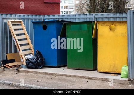 Tre grandi bidoni colorati per rifiuti e sacchetti per rifiuti Foto Stock