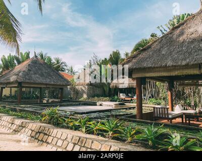 Bungalows in piedi tra vegetazione tropicale, circondato da palme. Un luogo dove rilassarsi e meditare. Rilassatevi in un paradiso tropicale Foto Stock