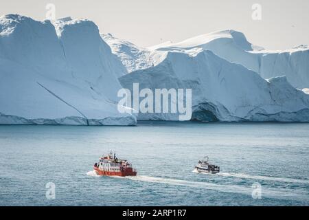 Tour in barca con Avvistamento di balene e orange con iceberg sullo sfondo. Vista verso Icefjord a Ilulissat. Baia Di Disko In Groenlandia. Iceberg che riflette Foto Stock