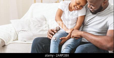 Primo piano di papà amorevole che solletico sua figlia piccola Foto Stock