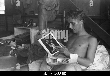 Mensa dell'Hotel Welfare a Kramat (Batavia) Soldier si trova a letto con un pacchetto aperto. Nelle sue mani il libro Griffioen di Francois Pauwels Annotazione: Il libro è apparso nel 1946 Data: 1947/01/01 Località: Indonesia, Indie Orientali olandesi Foto Stock
