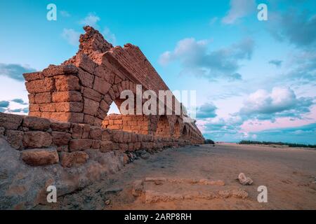 Acquedotto nella città antica Cesarea al tramonto. Colore creativo Foto Stock