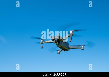 Drone pieghevole in volo nel cielo blu Foto Stock