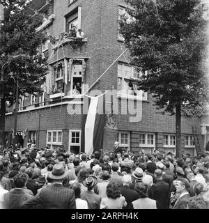 Intrattenimento folcloristico ad Amsterdam. Rep. Dei vari festeggiamenti dopo la liberazione nella capitale [incontro Festoso all'angolo di Euterpestraat e Rubensstraat, in occasione del cambio di nome della vecchia strada in Gerrit van der Veenstraat. Sulla facciata dell'edificio ad angolo, una bandiera olandese copre il nuovo cartello stradale. Il sindaco Feike de Boer recitazione dà un discorso Data: 28 giugno 1945 luogo: Amsterdam, Noord-Holland Parole Chiave: Liberation festival, seconda guerra mondiale Foto Stock