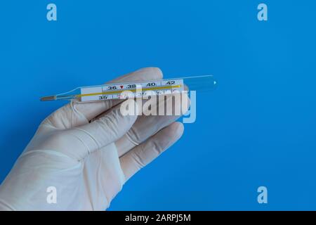 Guanti monouso bianchi, termometro, misurazione della temperatura. Coronavirus, dispositivi di protezione individuale, maschera medica monouso, farmaci con un'assunzione di sirine Foto Stock