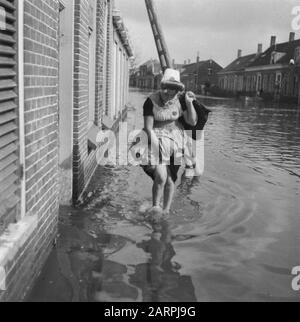 Walcheren: Herstelling Nollegat nella parete del mare e altri luoghi in Walcheren Woman in costume tradizionale passeggiate attraverso una strada allagata Data: Ottobre 1945 luogo: Walcheren Parole Chiave: Riparazione, seconda guerra mondiale, ricostruzione Nome personale: Nollegat Foto Stock