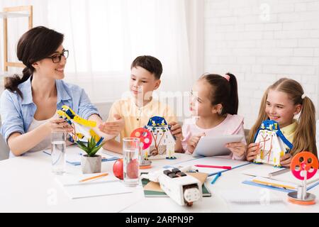 Insegnante che spiega ai bambini come fare un moderno robot Foto Stock