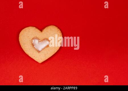 Dolci fatti a mano cute a forma di cuore su sfondo rosso. Concetto del giorno di San Valentino, sorprese con amore, vacanza, ecc Flat Lay, copia spazio. Foto Stock