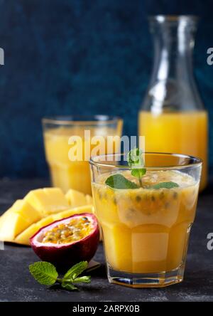 frullato mango frutto della passione in un bicchiere, fresco mango e frutto della passione su sfondo scuro Foto Stock
