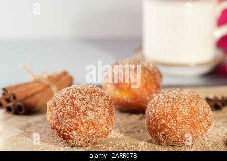 Gustosi buchi di ciambelle cosparsi di zucchero alla cannella sulla carta marrone sul tavolo. Dieting sfondo astratto. Orizzontale . Foto Stock