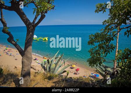 Spiaggia della costa con turisti in vacanza in una calda giornata estiva in Spagna Foto Stock