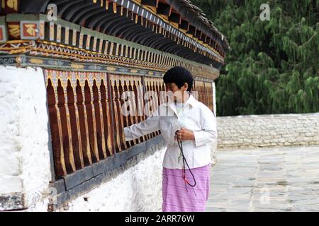 Una donna che circumdeambulante e Ruota di preghiera Rotante Ad UN tempiale in Bhutan di Thimpu Foto Stock