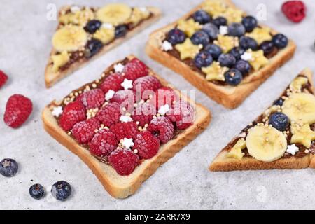 Cibo sano con fetta di pane tostato farro condito con frutti di lampone rosso e cereali di quinoa soffiato Foto Stock