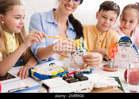 Scuola di scienza. Insegnante con alunni che costruiscono robot Foto Stock