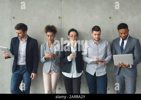 Mondo aziendale e digitale. Team diversificato che utilizza gadget moderni Foto Stock