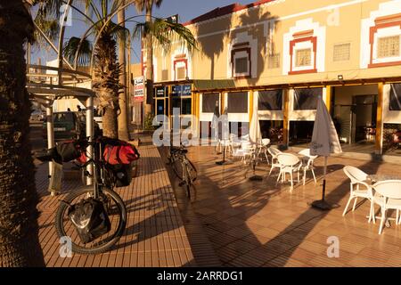 Una bici da turismo appoggiata contro un palo di fronte al ristorante a Tan Tan, Marocco Foto Stock