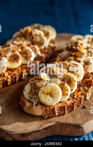 Fette di pane condite con burro di arachidi, miele e fette di banana Foto Stock