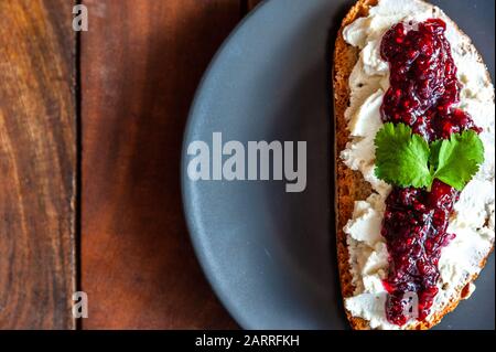 Dettaglio di una fetta di pane condito con ricotta e vasetto Foto Stock