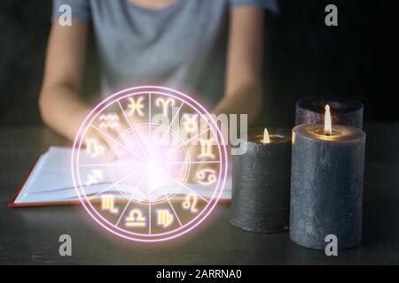 Candele brucianti sulla tabella dell'astrologo femminile Foto Stock