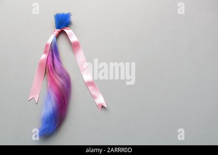 Capelli colorati tinti e nastro su sfondo grigio Foto Stock