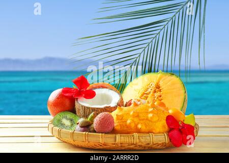 Assortimento di gustosi frutti esotici su tavola di legno presso il resort sul mare Foto Stock