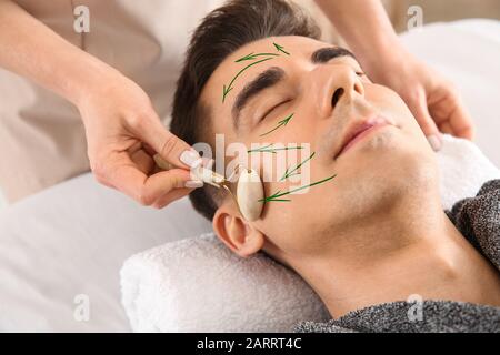 L'uomo riceve il massaggio del viso nel salone di bellezza Foto Stock