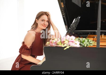 Bella giovane donna al pianoforte a coda Foto Stock