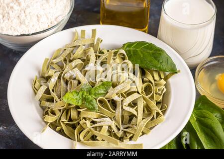 Pasta, verdure, erbe e spezie, olio d'oliva, ingredienti per la cucina italiana su sfondo scuro. Spazio di copia Foto Stock