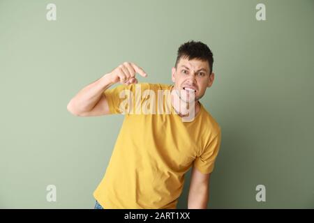 Ritratto di uomo arrabbiato su sfondo a colori Foto Stock