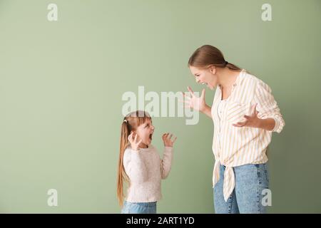 Ritratto di madre quarreling e figlia piccola su sfondo a colori Foto Stock