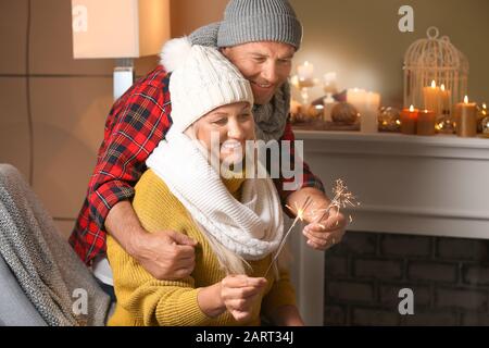 Felice Coppia matura in botti di Natale a casa Foto Stock
