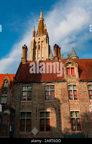 Torre della Chiesa di Nostra Signora di Bruges in Belgio con il farmacista del Sint-Janshospitaal in primo piano. Brugge, Bruges, Belgio. Foto Stock