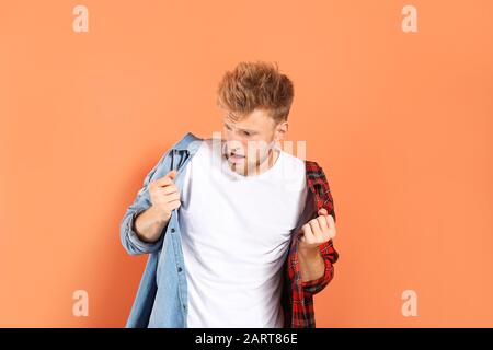 Ritratto di uomo sorpreso indossando camicie diverse su sfondo a colori Foto Stock