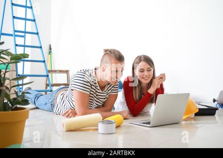 Felice coppia giovane con laptop riparazione di pianificazione nella loro nuova casa Foto Stock