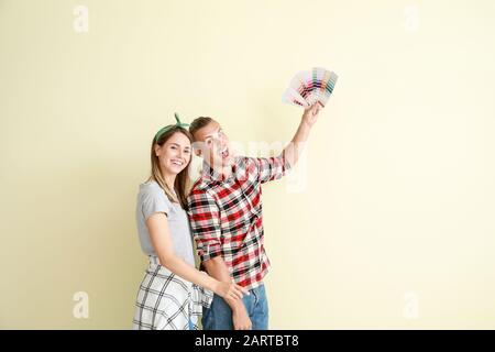 Felice coppia giovane scegliendo il colore delle pareti nella loro nuova casa Foto Stock