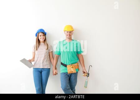Felice coppia giovane con strumenti su sfondo chiaro Foto Stock