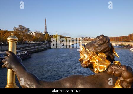 Torre Eiffel e fiume Senna visto in una soleggiata giornata autunnale dal ponte Alexander III a Parigi, dettaglio della statua Foto Stock