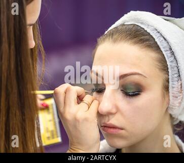 Makeup artista ciglia giovane donna nel salone di bellezza Foto Stock